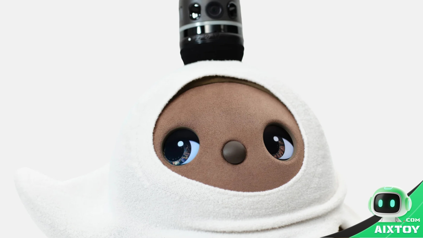 Close-up of a LOVOT companion robot wearing a white hooded garment, with its large eyes and soft fur filling the frame
